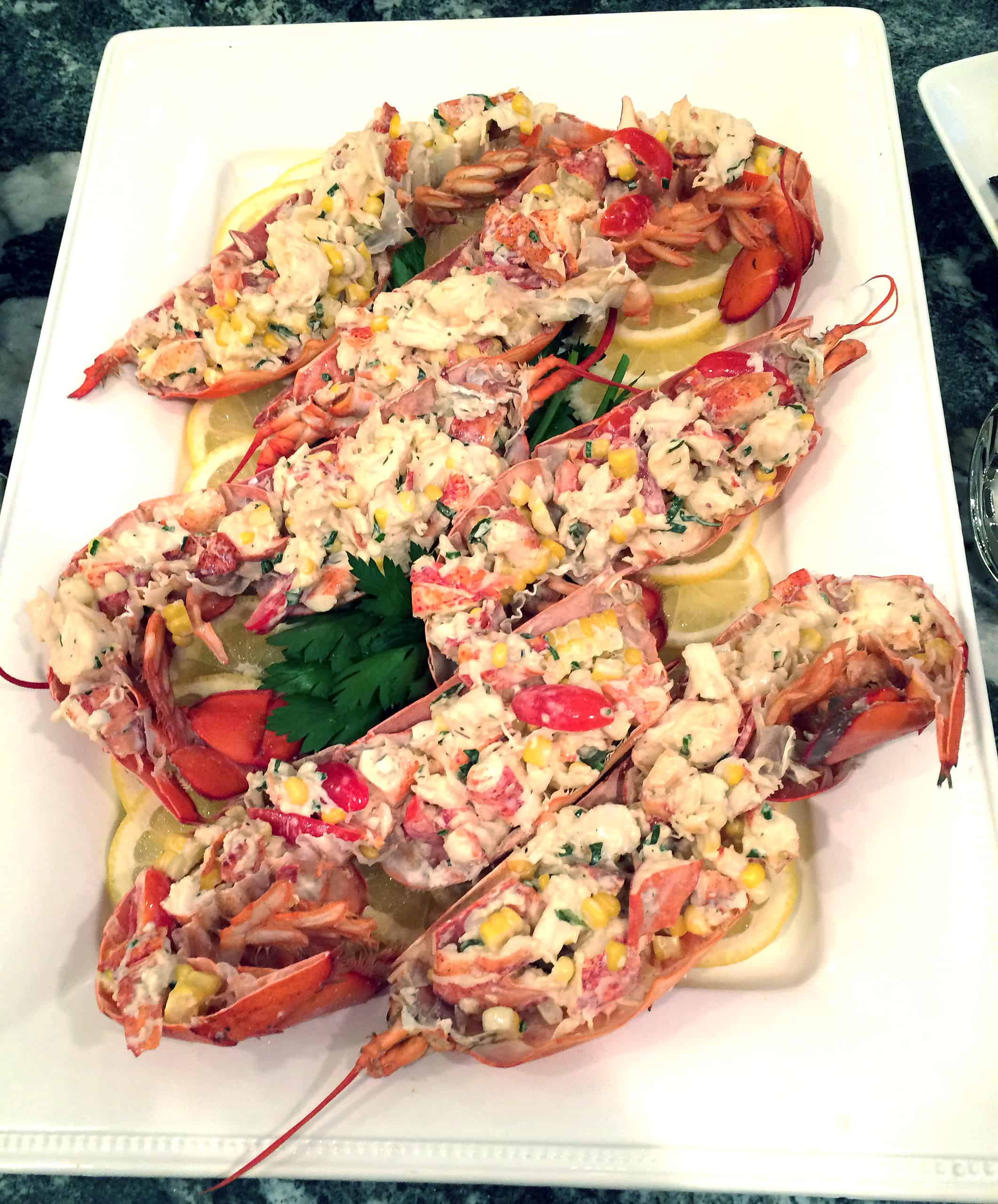Lobster tail salad with corn, tomatoes, and herbed dressing served in the shell