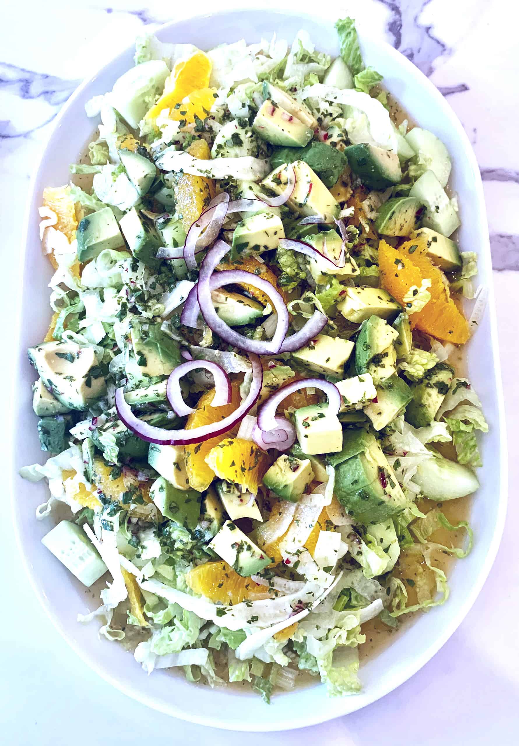 Salad with romaine, avocado, red onion, oranges, and herbs