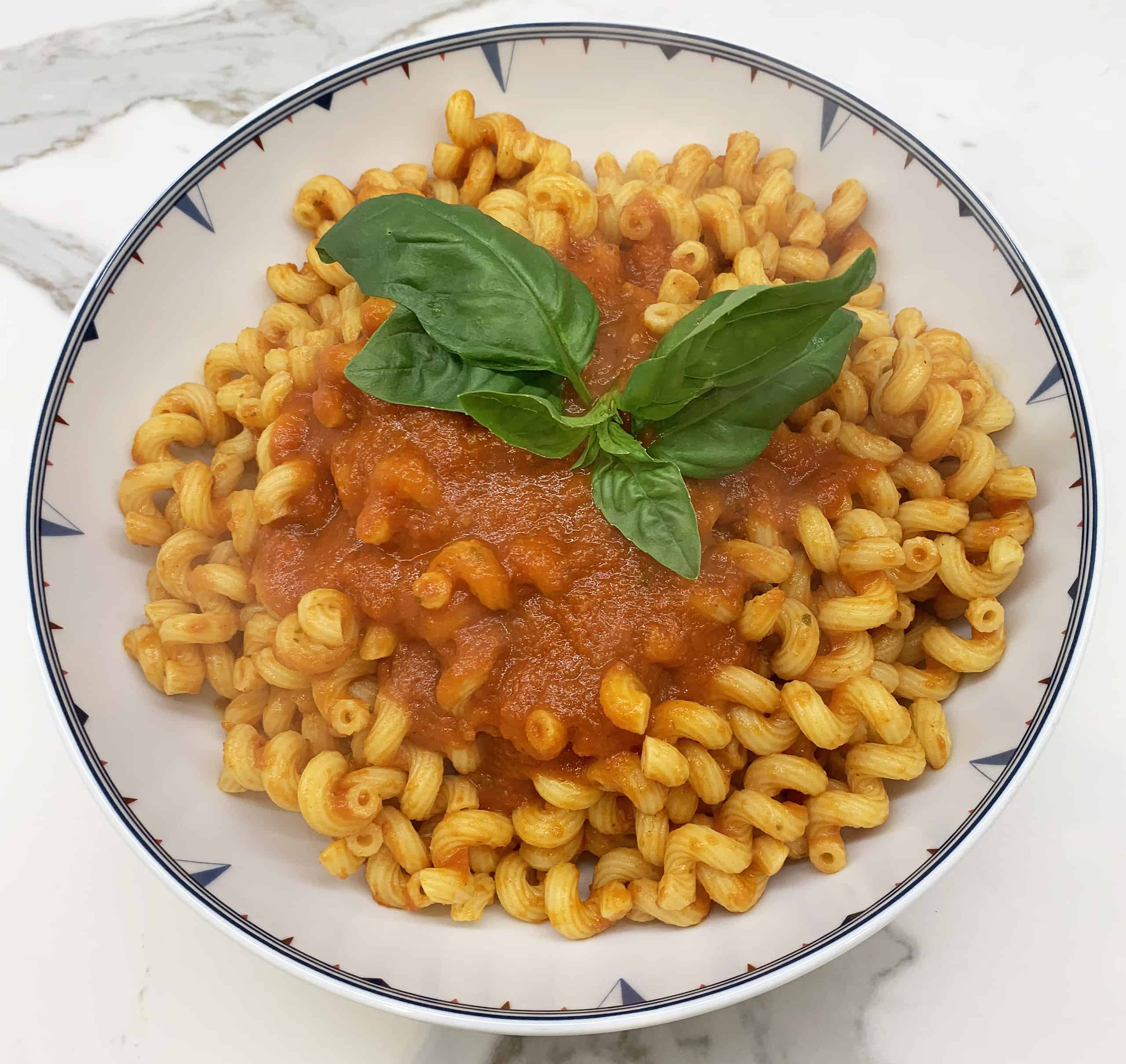 Cavatappi pasta with marinara sauce and basil