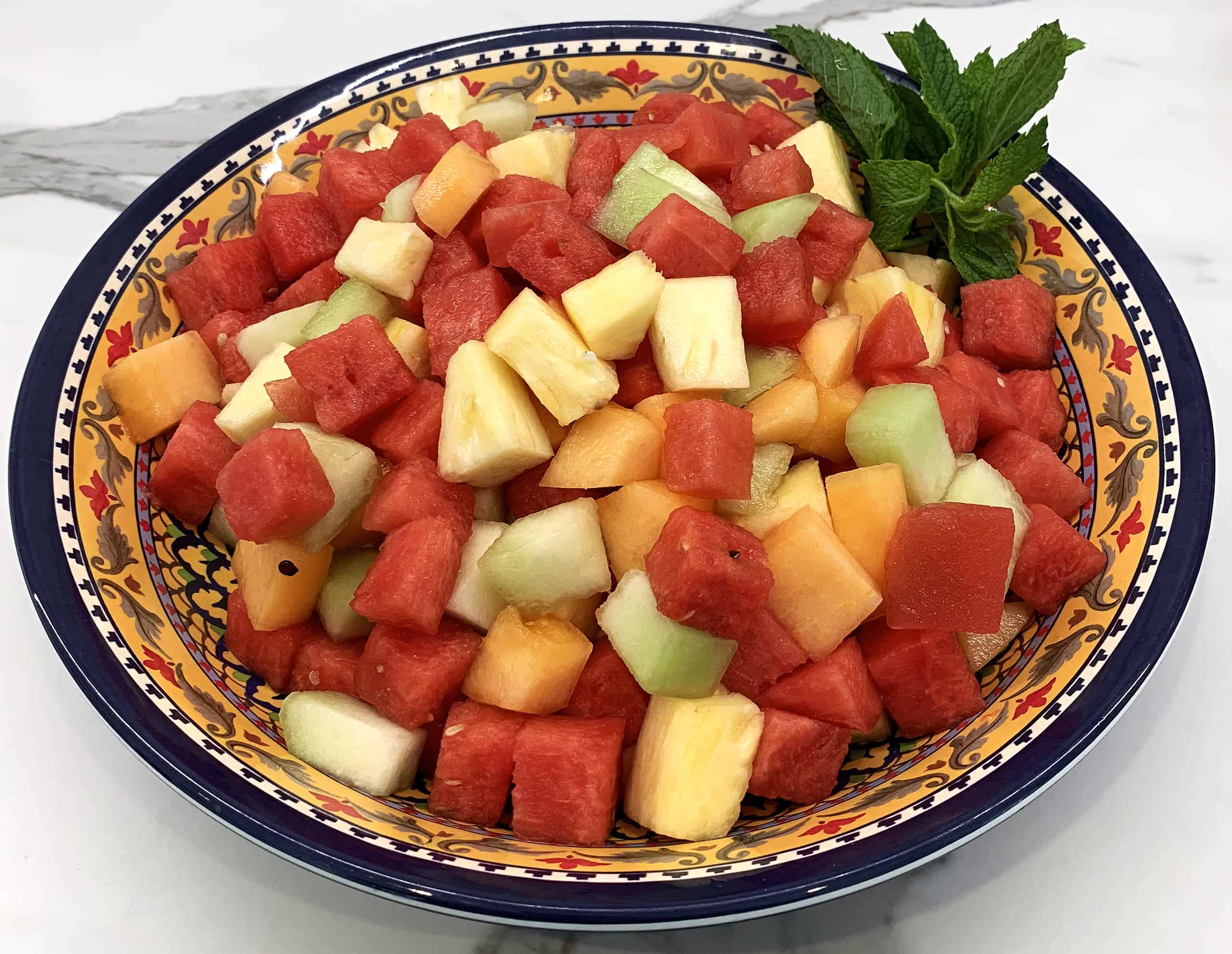 Fruit salad with, cantaloupe, watermelon, honeydew, and pineapple with mint garnish