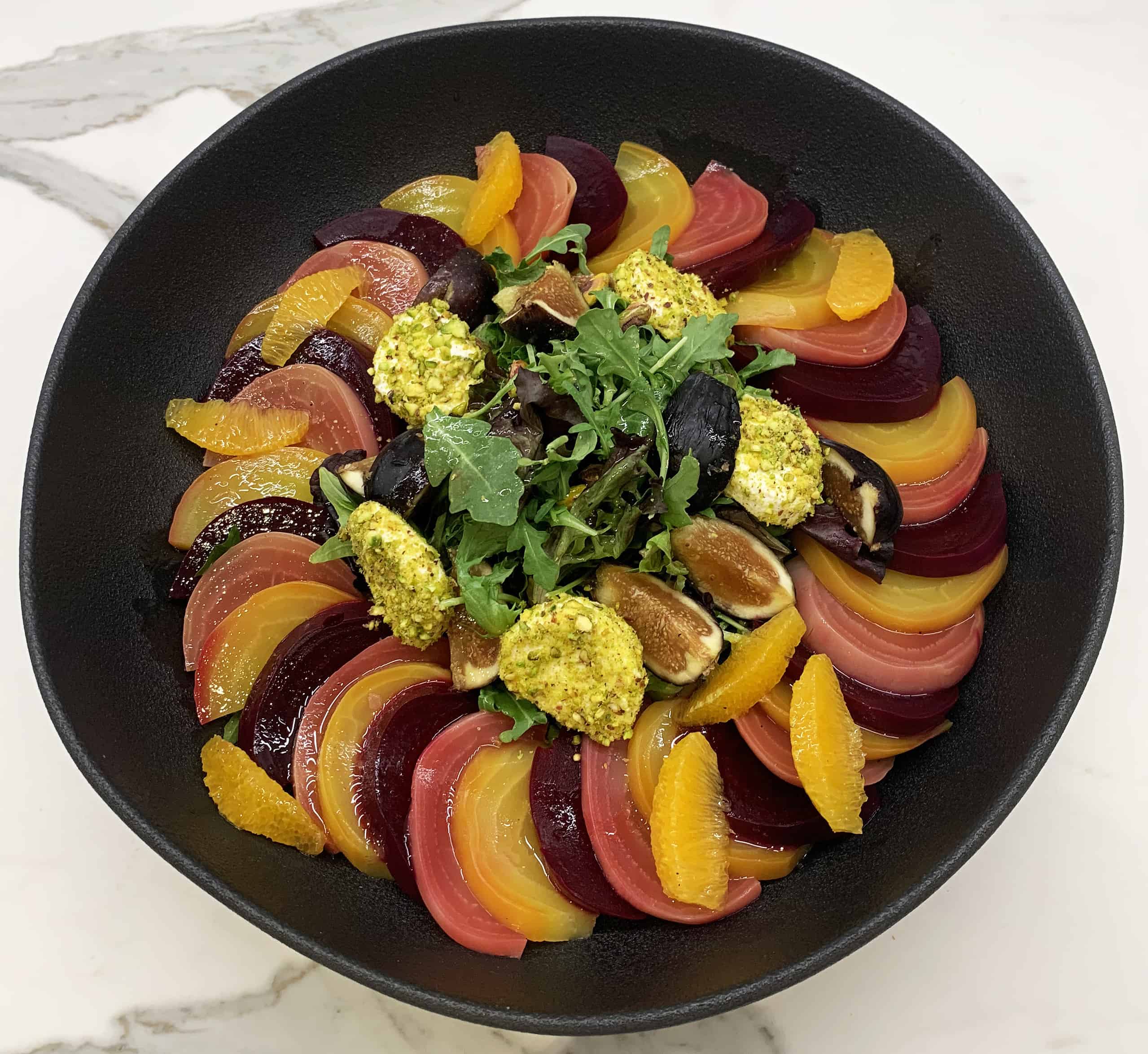 Mixed greens salad with beets, figs, and oranges and pistachios
